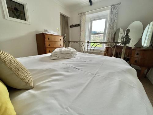 uma grande cama branca num quarto com uma janela em Attenborough Cottage - 2 Bedroom Cottage em Tredegar