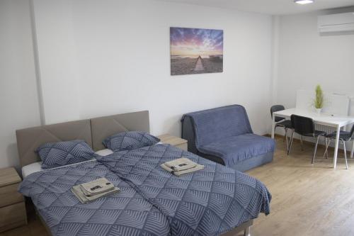 a bedroom with a bed and a chair and a table at City center apartment in Koper