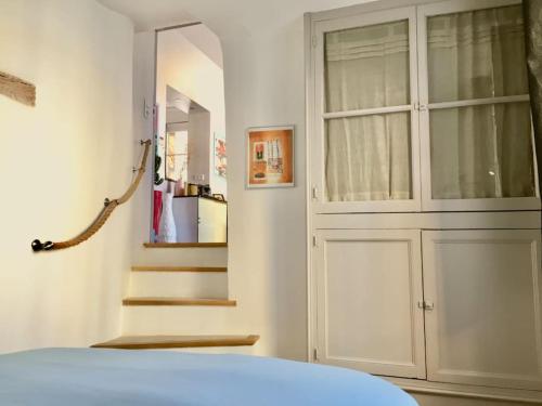 - une chambre avec une porte et un escalier dans l'établissement coeur du centre ville avec balcon, à LʼIsle-sur-la-Sorgue