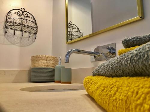 La salle de bains est pourvue d'un lavabo avec un robinet et un miroir. dans l'établissement coeur du centre ville avec balcon, à LʼIsle-sur-la-Sorgue