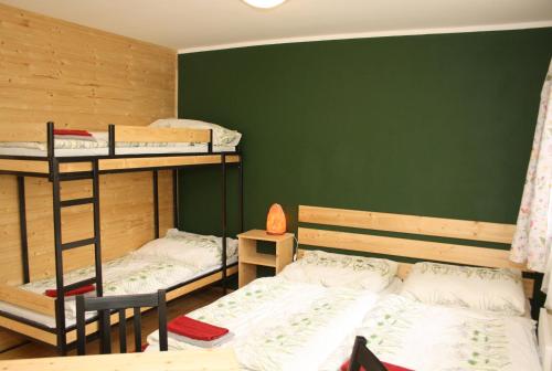 two bunk beds in a room with a green wall at Nad rybníkem Hnačov - rodinný rekreační areál in Hnačov