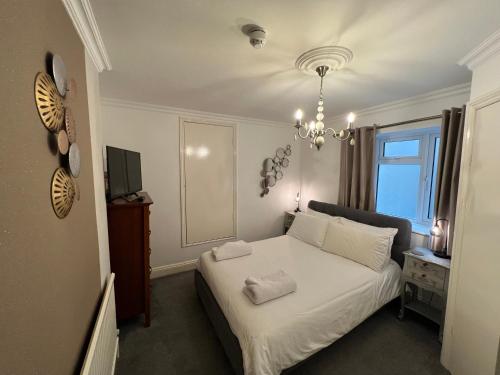 a bedroom with a white bed and a chandelier at Atlanta in Eastbourne