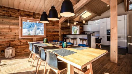 une cuisine et une salle à manger avec une table et des chaises en bois dans l'établissement Chalet du Bois, à Chamonix-Mont-Blanc