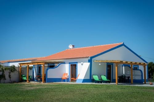 a small house with a blue at Monte Da Baía Do Tonel in Zambujeira do Mar