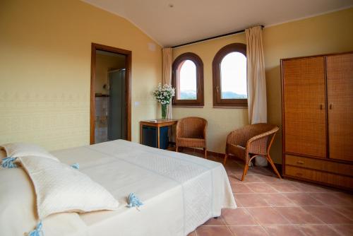 una camera con letto, tavolo e sedie di S'ena Hotel ad Arbus