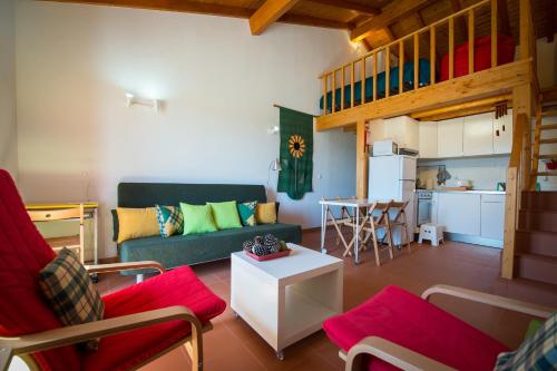 a living room with a couch and a kitchen at Monte Da Baía Do Tonel in Zambujeira do Mar