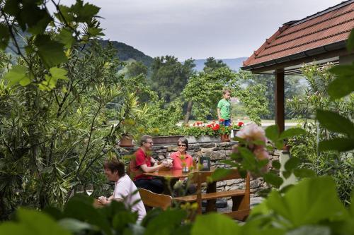 a group of people sitting at a table in a garden at Winzerhof - Gästehaus Stöger in Dürnstein