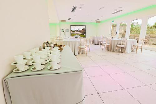 una stanza con tavoli bianchi e tazze e sedie bianche di The Grange a Upper Arley