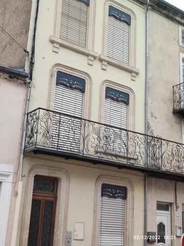 un bâtiment avec un balcon sur le côté dans l'établissement Appartement 1er etage proche des Termes, à Bourbonne-les-Bains