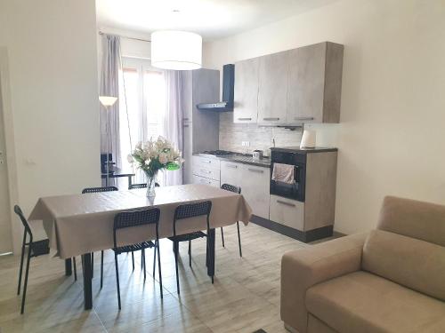 a kitchen and dining room with a table and a couch at Savannah Charme Apartment in La Spezia