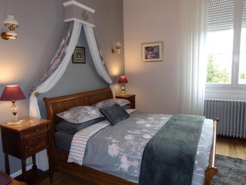 a bedroom with a bed with a canopy at La Maison Ribotteau in LʼIsle-Jourdain