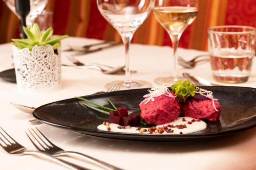 a plate of food on a table with wine glasses at Hotel Stubaierhof in Neustift im Stubaital