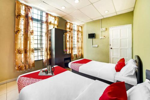 two beds in a room with red and white at Hotel Lii View in Mersing