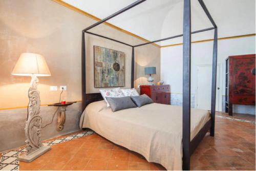 a bedroom with a canopy bed and a lamp at Atrani House-AMALFI in Atrani