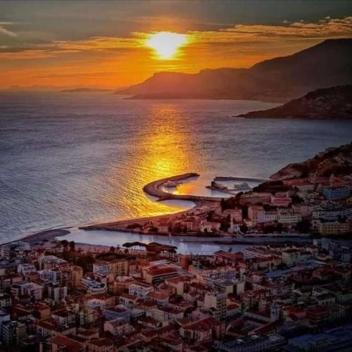 a sunset over a city and the ocean with a beach at Da Dharma in Ventimiglia