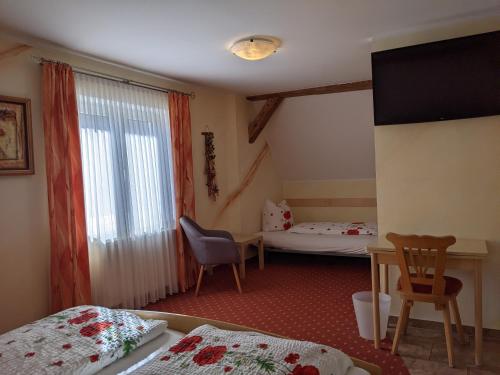a room with two beds and a table and a window at Gasthof Adler in Zusmarshausen