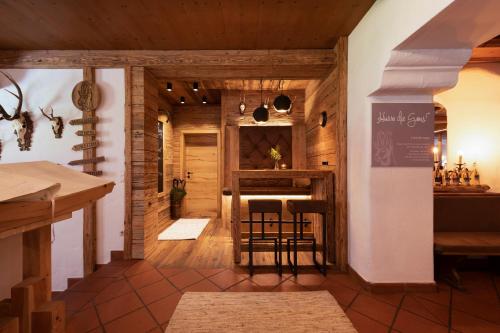 a kitchen with wooden walls and a bar with stools at Hotel Stubaierhof in Neustift im Stubaital