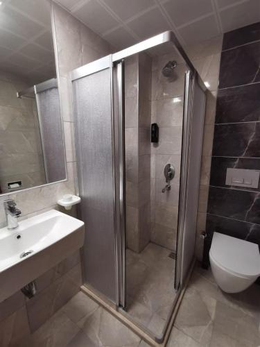 a bathroom with a shower and a sink and a toilet at Club Pink Palace Hotel in Oludeniz