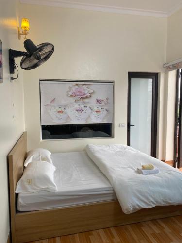 1 cama en una habitación con una foto en la pared en Nhà Nghỉ Hương Trà Minh Đài 