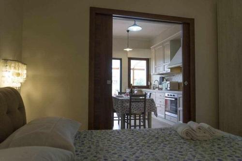 Cet appartement comprend une chambre avec un lit et une cuisine avec une table. dans l'établissement Appartamento a 200 metri dal mare Granseola, à Alghero