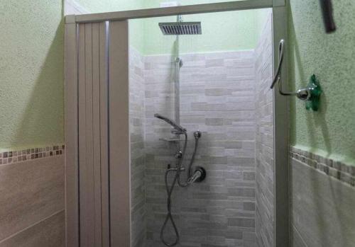 La salle de bains est pourvue d'une douche avec une porte en verre. dans l'établissement Appartamento a 200 metri dal mare Granseola, à Alghero