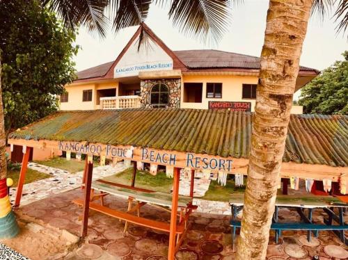a beach resort with a bench in front of a building at Kangaroo Pouch Beach Resort in Busua