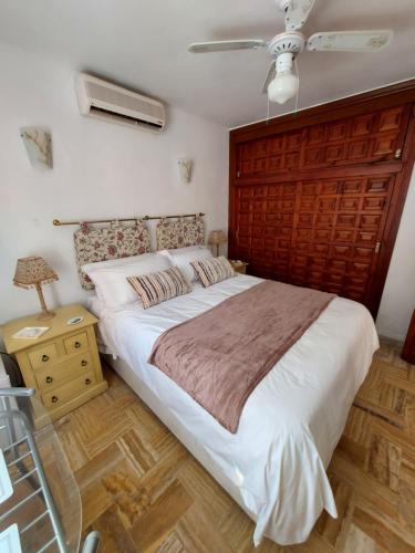 a bedroom with a large bed with a wooden headboard at Mi Casa in Turre