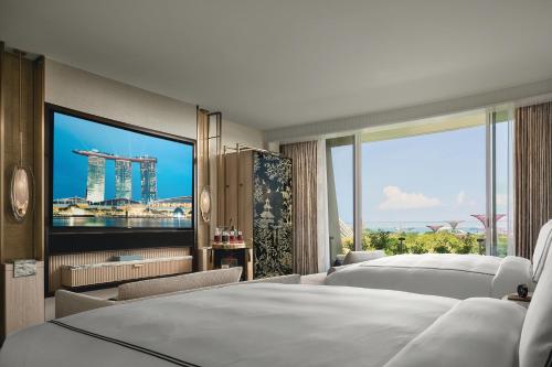 um quarto de hotel com duas camas e uma televisão de ecrã grande em Marina Bay Sands em Singapura