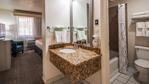 a hotel bathroom with a sink and a toilet at Best Western Inn Tooele in Tooele