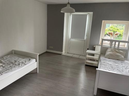 a bedroom with two beds and a window and a door at Dill Apartments Gr. Lafferde in Ilsede