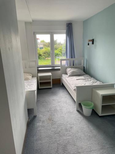 a bedroom with two beds and a window at Dill Apartments Gr. Lafferde in Ilsede