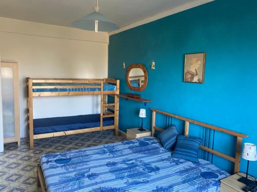 1 dormitorio con 2 literas y pared azul en Villa Marie Claire en Ischia