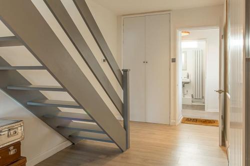 a staircase in a room with a stair case at Modern 2 BD w/ Garden in the Heart of Tetbury! in Tetbury