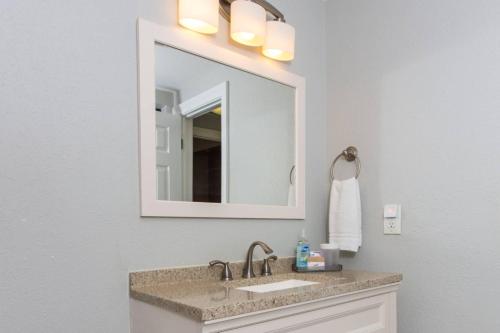La salle de bains est pourvue d'un lavabo et d'un miroir. dans l'établissement Cozy Retreat-348 Miracle Strip Pkwy SW, Suite 8A, FT Walton Bch, FL 32548, à Fort Walton Beach