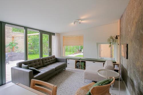 una sala de estar con un sofá y una mesa en Diva in de Duinen - Park Duinland Sint Maartenszee, en Sint Maartensvlotbrug