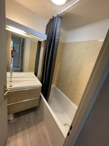 a bathroom with a tub and a sink and a shower at Appartements Confort Saint François Longchamp in Saint-François-Longchamp