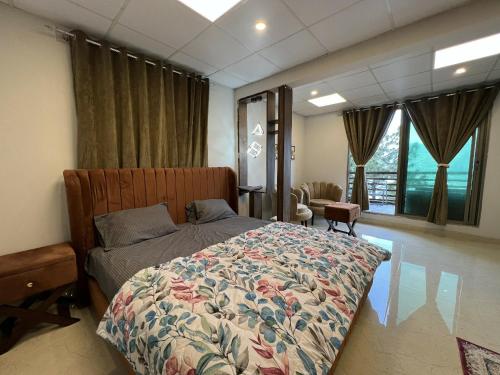 1 dormitorio con 1 cama con colcha de flores en The Realtors Inn Luxurious Cottage Murree en Murree