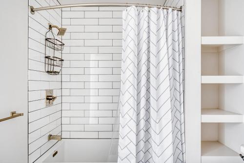 a white bathroom with a shower curtain and a tub at Oakland 1BR w AC WD Sky Deck next to BART SFO-524 in Oakland