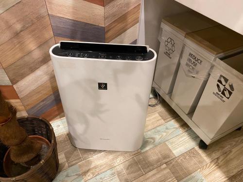 a washing machine sitting on the floor next to boxes at Hotel Jungle fun fun in Osaka