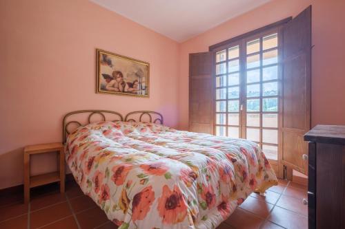 a bedroom with a bed with a floral bedspread and a window at Green Health in Messina