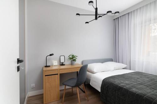a bedroom with a desk with a bed and a chair at Easy Rent Apartments - WETTERA II in Lublin