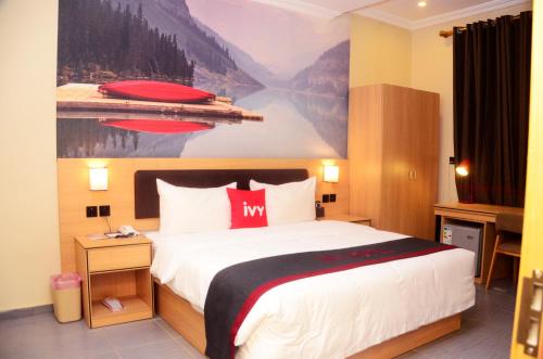 una camera d'albergo con un letto e un dipinto sul muro di Ivy Hotel Emerald a Ikeja