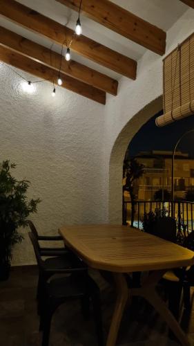 a wooden table in a room with a table and chairs at Hello Oliva Beach Alter in Oliva