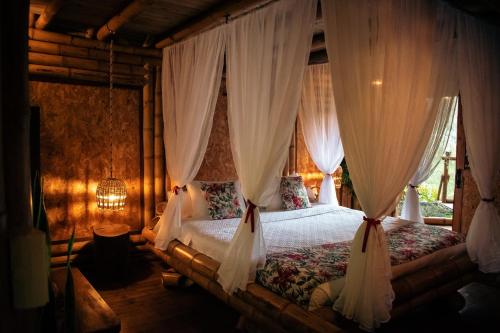 ハルディンにあるCabaña Manantial del Turpialのベッドルーム(白いカーテン付きのベッド1台付)