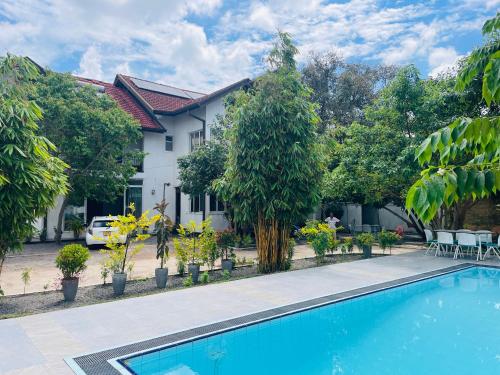 a villa with a swimming pool in front of a house at Aradhana Airport Transit hotel in Katunayaka