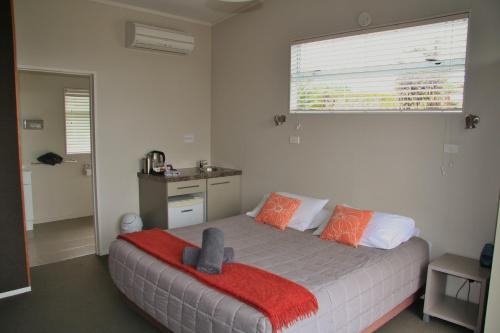 a bedroom with a bed with a large window at Taupo Debretts Spa Resort in Taupo
