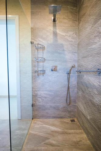 a shower with a glass door in a bathroom at Beautiful Villa with Breathtaking Views in Swieqi by 360 Estates in Is-Swieqi