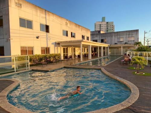 un hombre nadando en una piscina en un edificio en Pérola de Piatã, en Salvador