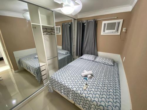Dormitorio pequeño con cama y espejo en Pérola de Piatã, en Salvador