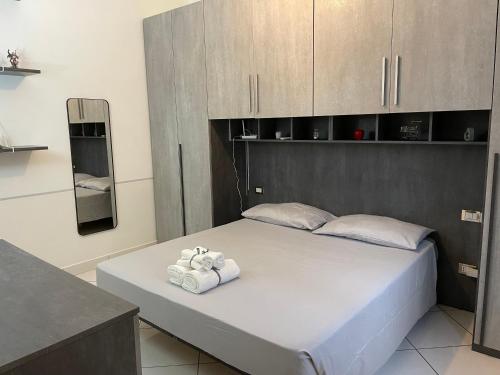 1 dormitorio con 1 cama con toallas en TheMaki'sHouse en Fiumicino